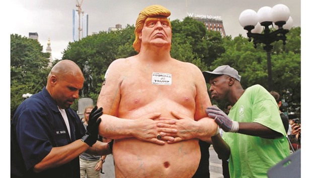 New York City Parks workers move a naked statue of US Republican presidential nominee Donald Trump that was left in Union Square Park in New York City.