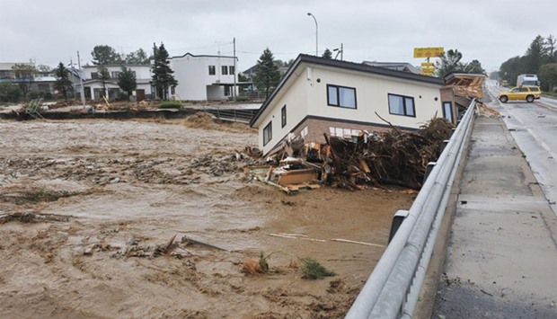 This picture shows a house swept down a river at the town of Shimizu in Hokkaido prefecture, after Typhoon Lionrock struck over