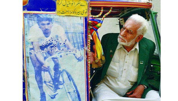 This file photo shows former Pakistani Olympian Muhammad Ashiq waiting for passengers in his auto-rickshaw in Lahore.