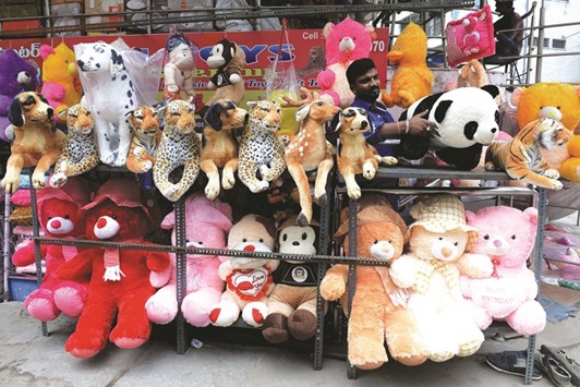 A vendor arranges stuffed animals and plush toys outside his shop at a wholesale market in Hyderabad.
