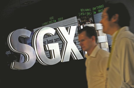 People walk past an SGX logo in Singapore. In a statement yesterday, the bourse said it sought to acquire from Baltic shareholders their issued ordinary share capital for u00a3160.41 in cash per share, representing a total consideration of u00a377.6mn.