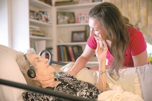 MEETING GRANDMA: Kerry Morris, one of Margaret Colemanu2019s 48 grandchildren, visits with her at the Coleman family home in Chicago. Although she is on oxygen and can no longer walk, Margaret remains in high spirits and wishes to stay in the family house, so her children organise and take turns caring for her during the week. She also receives frequent visits from many of her 48 grandchildren and 13 great-grandchildren.