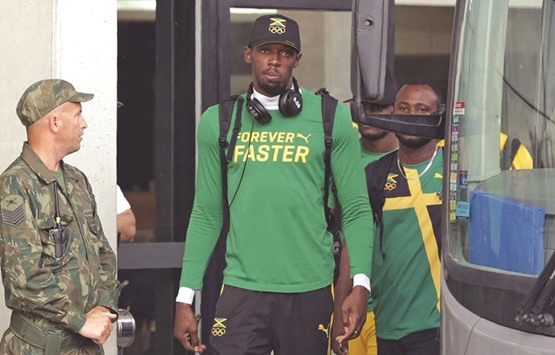 Jamaicau2019s Usain Bolt (C) leaves his hotel to attend a training session.