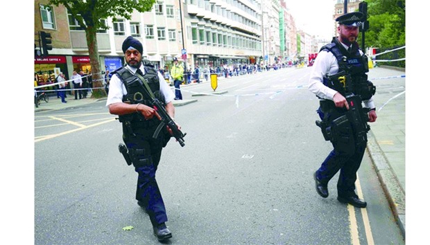 Armed police officers patrol at the scene of the knife attack in Russell Square in London.