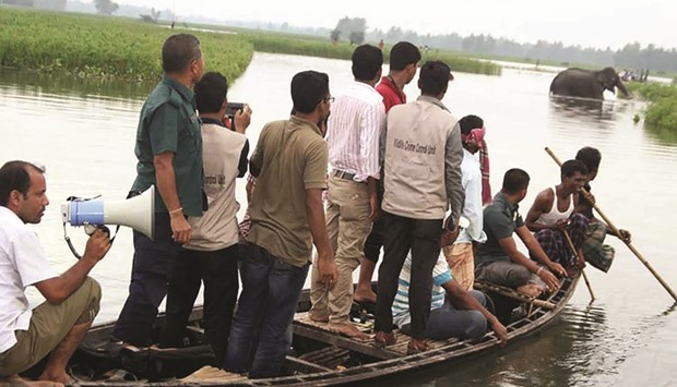 Bangladesh wildlife officials observe a wild elephant in a watercourse at Sarishabari in Jamalpur District some 150kms north of Dhaka.