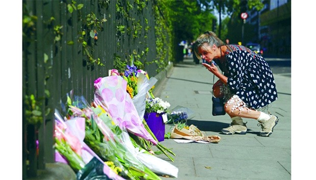 A woman places flowers and a written message beside other floral tributes near the crime scene at Londonu2019s Russell Square.