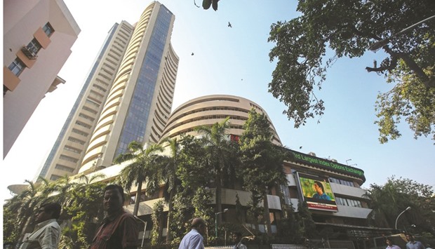 People walk by the Bombay Stock Exchange building in Mumbai. The Sensex closed up 1.31%  to 28,078.35 points, marking its biggest single-session gain since July 11.
