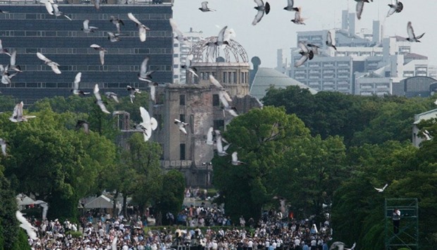 Doves fly over the Hiroshima Peace Memorial Park in western Japan on August 6, 2016 during a memorial service to mark the 71st anniversary of the atomic bombing of Hiroshima