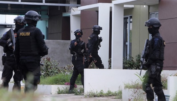 Indonesian anti-terror police are seen entering a building during a raid