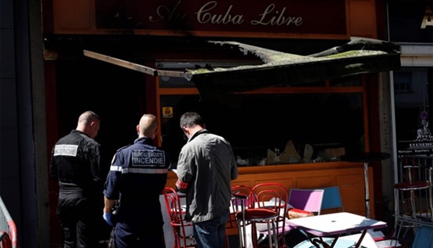 Police officers and firefighters inspect the damaged Au Cuba Libre bar in Rouen