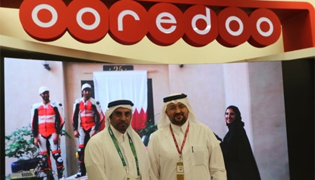 Waleed al-Sayed, Ooredoo Group deputy chief executive officer (right) at the solutions booth inside 