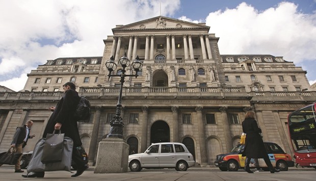 Pedestrians and taxi cabs pass the Bank of England headquarters in London. The BoEu2019s corporate-bond purchase programme, announced on Thursday, has been met by scepticism from some credit market analysts.