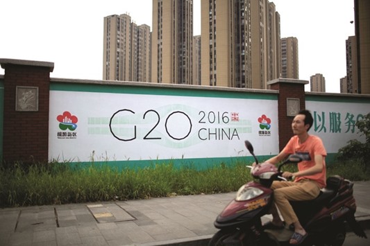A man rides an electronic bike past a billboard for the upcoming G20 summit in Hangzhou, Zhejiang province, China. Having gone from being a recipient of FDI to a net contributor in recent decades, China is perfectly positioned to lead G20 discussions on global development.