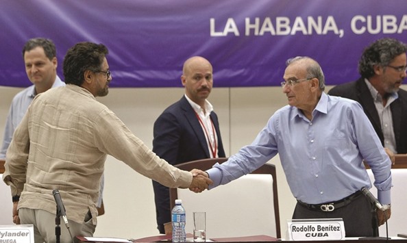 The head of the Colombian government delegation and a FARC negotiator shake hands during a press conference in Havana.
