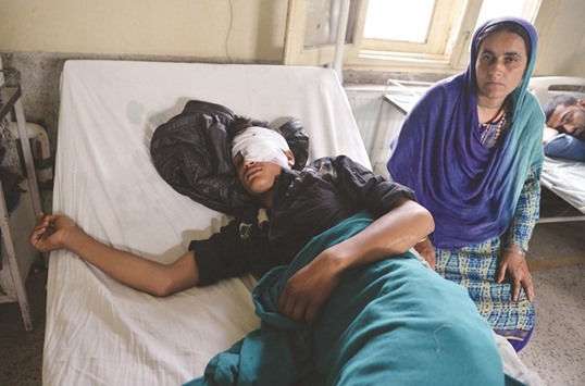 A Kashmiri woman sits alongside her sleeping son, who is being treated for an eye injury in a hospital after being hit by pellets fired by Indian security forces during a protest on August 5, in Srinagar yesterday. Hospitals in Kashmir are overwhelmed, with new hundreds of wounded patients pouring in as the region reels of clashes between anti-India protesters and government troops More than 50 people have been killed and thousands injured in weeks of unrest in Indian-administered Kashmir, sparked by the death on July 8 of popular rebel commander Burhan Wani in a firefight with government forces.