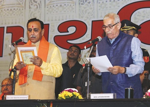Gujarat Governor O P Kohli administers the oath of office to Vijay Rupani during a swearing-in ceremony in Gandhinagar yesterday.