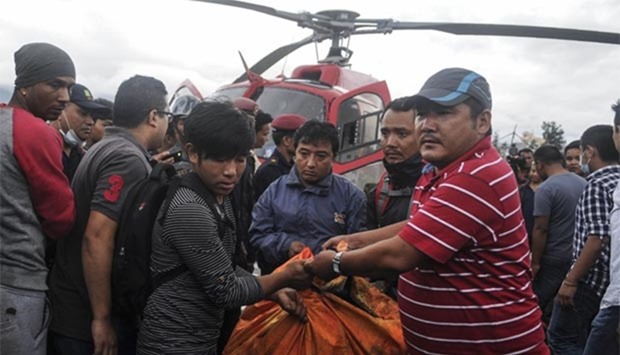 Nepalese officials carry the remains of those killed in a helicopter crash, in Kathmandu on Monday.