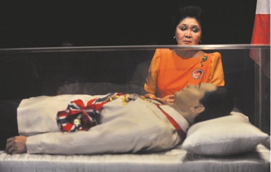 This file photo taken on March 26, 2010 shows former Philippine first lady Imelda Marcos looking at the embalmed body of her husband former leader Ferdinand Marcos prior to an election campaign trip in the town of Batac, Ilocos norte province, north of Manila.