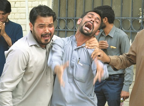 Pakistani bystanders react at the site after a bomb explosion at a government hospital premises in Quetta yesterday.