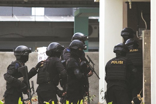 Indonesian anti-terror police conducting a raid at a house in Batam on Friday.