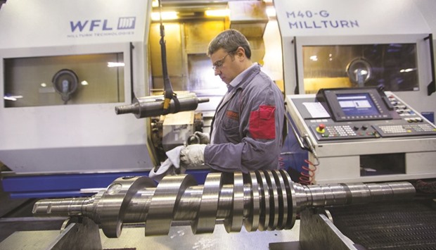 An employee shapes and surfaces compressing pump screws at the Oerlikon Leybold Vacuum factory in Cologne. German industrial output rose 0.8% on the month, data from the Economy Ministry showed yesterday, above the consensus forecast of 0.7% in a Reuters poll.