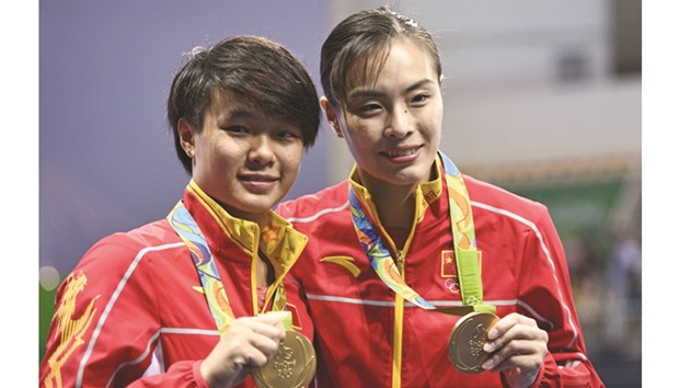 Gold medallists Chinau2019s Wu Minxia (right) and Shi Tingmao pose during the podium ceremony for the womenu2019s synchronised 3m springboard final on Sunday. (AFP)