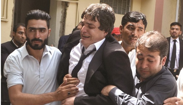 Friends comforting a lawyer after the killing of his colleagues in the bomb explosion s in Quetta yesterday.
