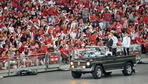 Singapore President Tony Tan Keng Yam waves to spectators from a moving jeep during the National Day celebrations in the city state on Tuesday.