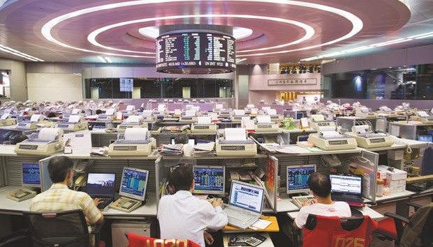 Traders work at the Hong Kong Stock Exchange. The Hang Seng Properties Index is valued at 0.8 times net assets, down from as high as 2 times in 1997, according Bloomberg data.