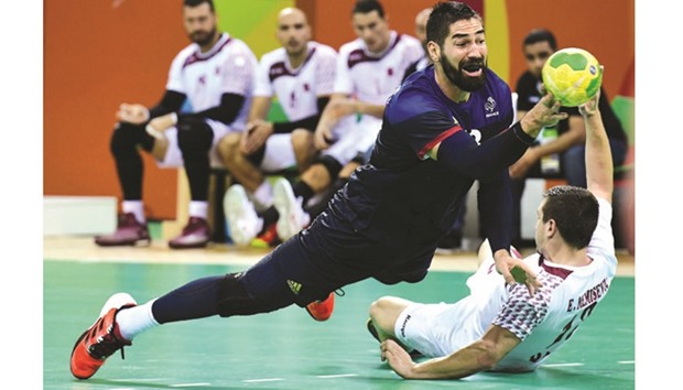 Qataru2019s Nasreddine Megdich (right) challenges Franceu2019s Nikola Karabatic during the menu2019s preliminary round Group A handball match at the Future Arena in Rio de Janeiro yesterday. (AFP)
