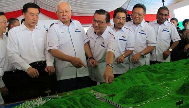 Malaysia's Prime Minister Najib Razak and Transport Minister Liow Tiong Lai look at a model of the E
