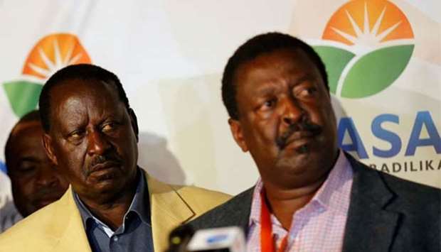 Kenyan opposition leader Raila Odinga listens as his campaign team manager Musalia Mudavadi addresses a news conference in Nairobi on Thursday