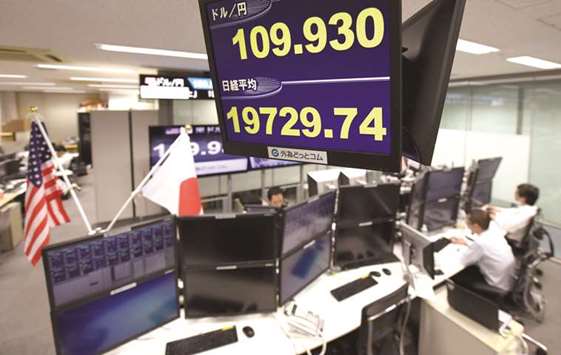 The yen rate against the US dollar and a share prices of the Tokyo Stock Exchange (bottom) are displayed at the dealing room of a foreign exchange brokerage in Tokyo. The Nikkei 225 yesterday lost less than 0.1% to 19,729.74 points.