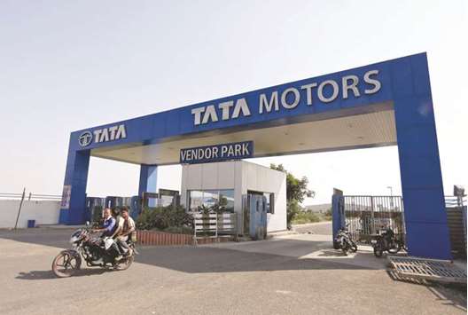 Men ride a motorbike as they come out of a Tata Motorsu2019 car plant at Sanand in the western Indian state of Gujarat. The company, which is struggling to boost sales, has been trying to turn around its loss-making domestic business by modernising its products, improving efficiency and streamlining its organisation.