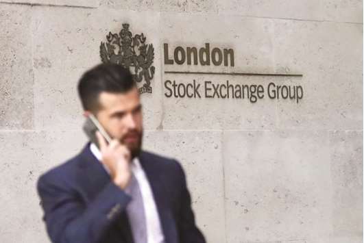 A pedestrian walks past the London Stock Exchange. The benchmark FTSE 100 index lost 1.4% to 7,389.94 points yesterday.