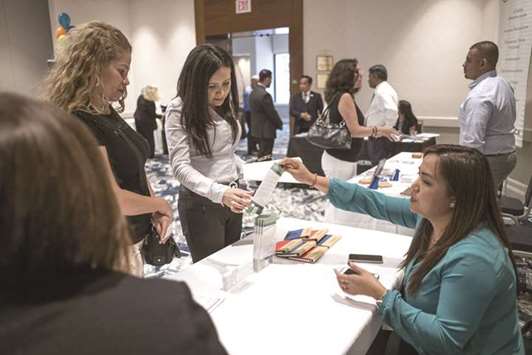 Job seekers speak to a recruiter during a career fair in San Jose, California. Labour Department data yesterday showed an increase in the number of Americans filing for unemployment benefits last week.