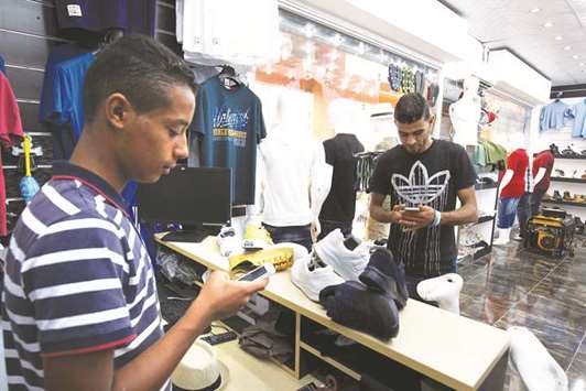 A Libyan uses a mobile phone app in Benghazi to pay at a store that accepts electronic payment systems.