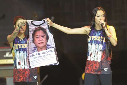 Mocha Uson a blogger and supporter of Philippine President Rodrigo Duterte, onstage with her colleague displaying a T-shirt decorated with a mugshot of arrested legislator Senator Leila De Lima during a pro-Duterte rally.
