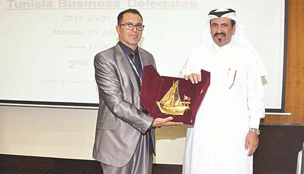 Qatar Chamber vice-chairman Mohamed bin Towar al-Kuwari presents a token of appreciation to Sami Gabsi, the vice-president of the Tunisian association, Namaa.