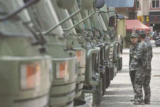 Chinese soldiers stand next to trucks at a temporary camp in Zhangzha, Sichuan province.
