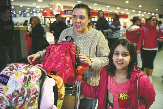 Valeria Marsili, wife of Gabriel Aguero, an Argentinean chef who works in Doha, and their daughters arrive at Ezeiza international airport in Buenos Aires on Wednesday.