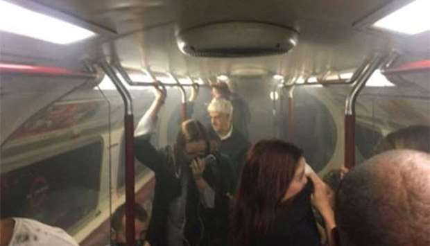 Passengers cover their faces as a carriage on a Bakerloo Line train starts to fill with smoke, at Oxford Circus station in London, on Friday.