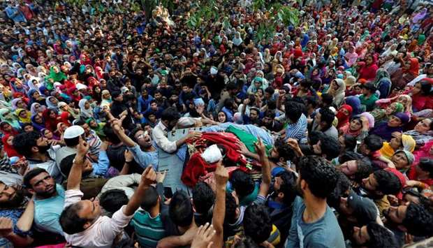 People shout slogans as they gather around the body of Shabir Ahmad Mir, a suspected militant
