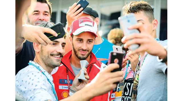 Andrea Dovizioso (C) of Italy makes selfies with fans during the MotoGP Austrian Grand Prix weekend at Red Bull Ring in Spielberg, Austria yesterday.  AFP