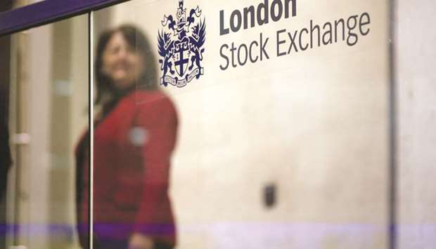 A visitor passes a sign inside the London Stock Exchange. The FTSE 100 closed down 1.1% to 7,309.96 points yesterday.