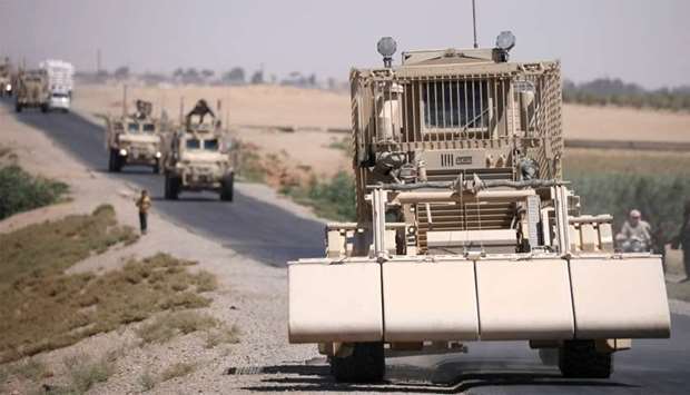 A US military demining vehicle leads a convoy on the main road in Raqqa