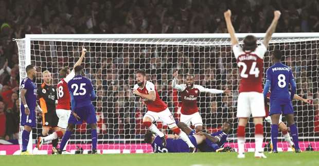 Arsenalu2019s French striker Olivier Giroud (centre) celebrates after scoring the winner during the English Premier League match against Leicester City at the Emirates Stadium in London. (Reuters)