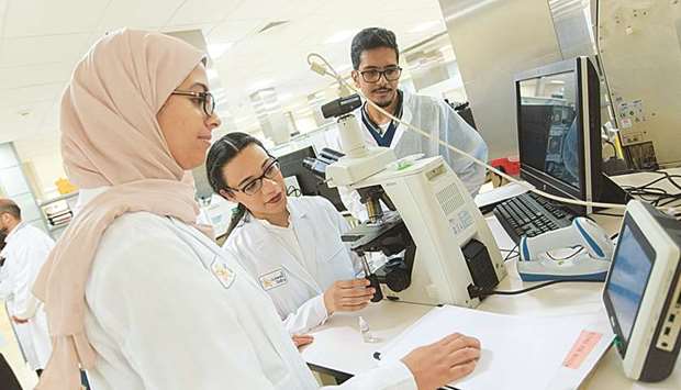 Aya Ebd Elaal, Rayan Hashim and Hasan al-Mana at the Sidra pathology lab.