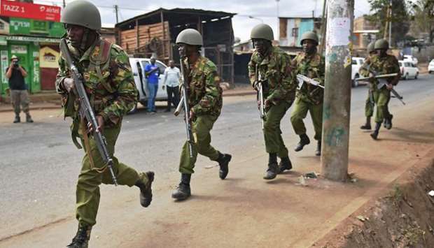 Armed Kenyan police run to disperse protesters in the Kibera slum in Nairobi