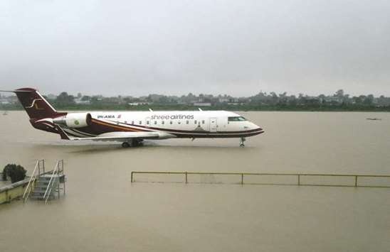 An aircraft is seen parked on the flooded apron of Biratnagaru2019s domestic airport after heavy rains in Biratnagar, some 240km from Nepalu2019s capital Kathmandu.